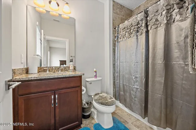 a bathroom with a granite countertop sink toilet and shower