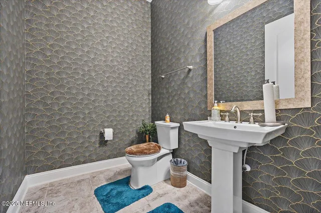 a bathroom with a sink toilet and mirror