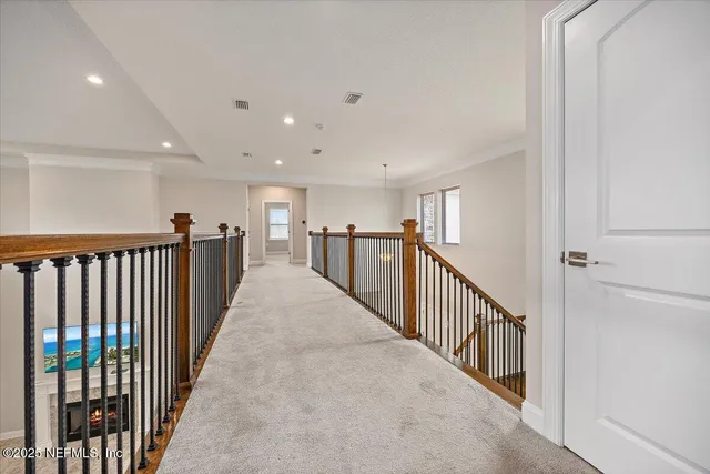a view of a hallway with wooden floor and stairs