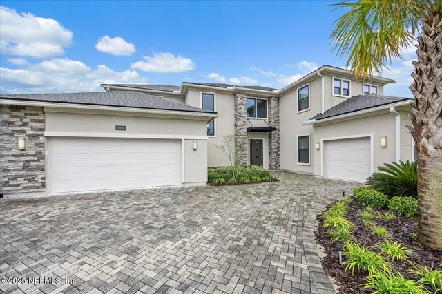 a front view of a house with a garden and garage