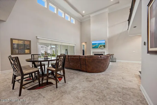 a living room with furniture a dining table and a refrigerator