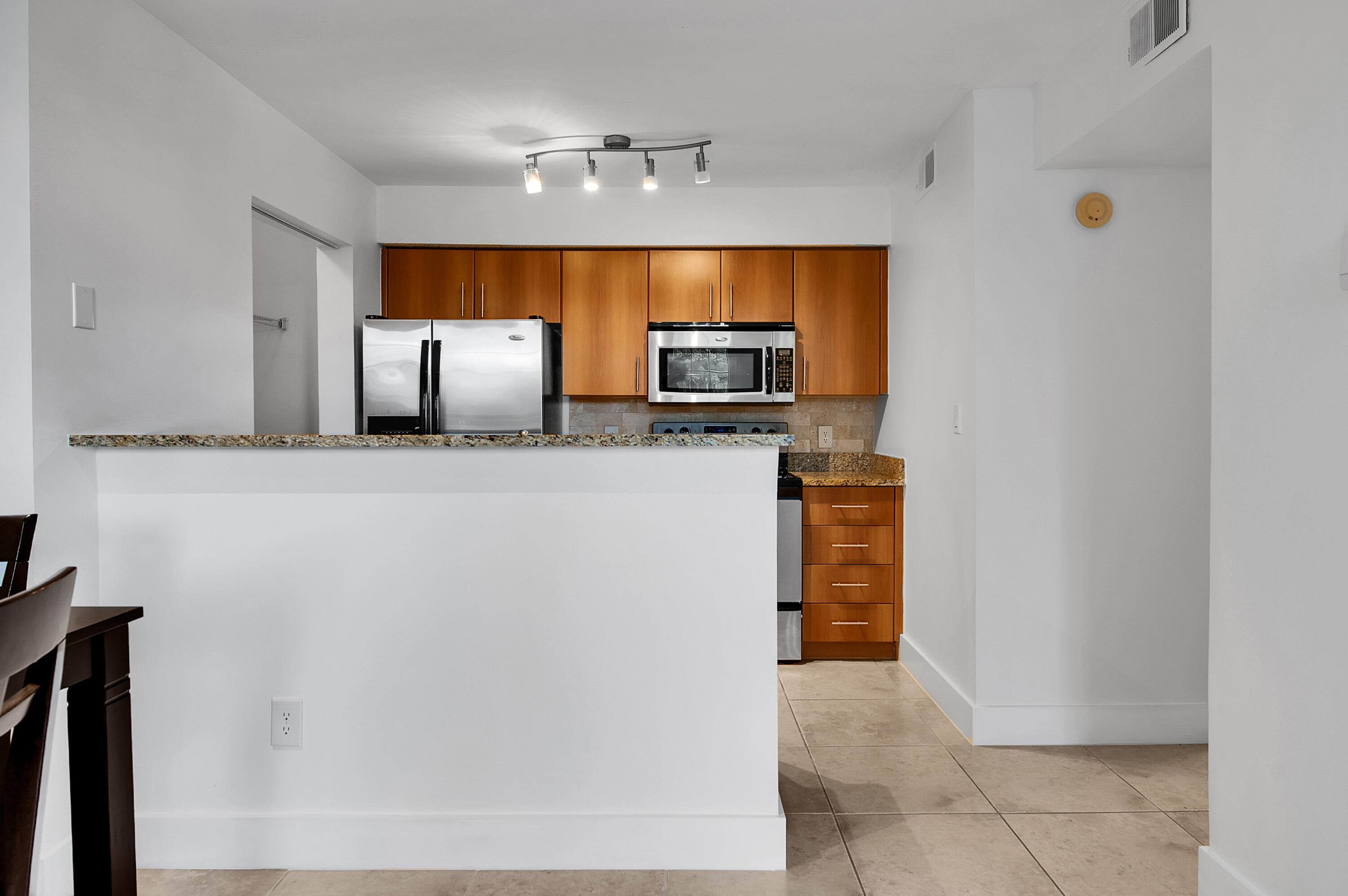 1275 Crystal Way, Unit K Delray Beach, FL 33444 - Photo 14 of 45 a kitchen with granite countertop a refrigerator and a sink