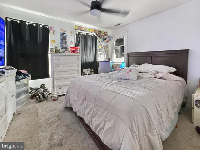 a bedroom with a bed a couch and a flat tv screen