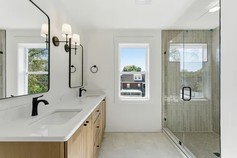 a bathroom with a granite countertop sink a mirror and shower