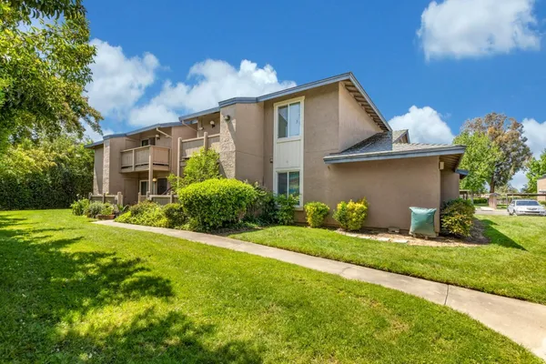 a view of backyard of house with green space