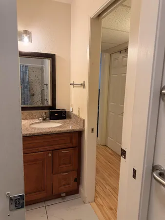 a bathroom with a granite countertop sink and a mirror
