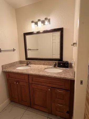 a bathroom with a granite countertop sink and a mirror