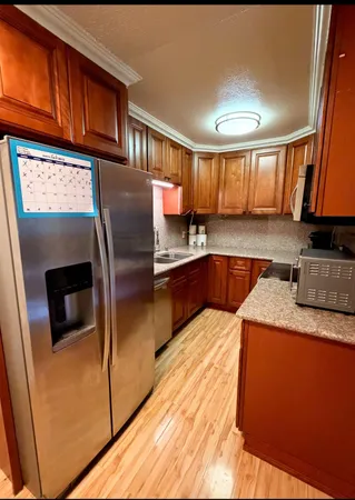 a kitchen with stainless steel appliances granite countertop a sink refrigerator and microwave