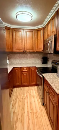 a kitchen with stainless steel appliances granite countertop a sink stove and cabinets