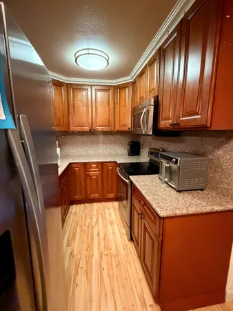 a kitchen with granite countertop stainless steel appliances a sink stove top oven and cabinets