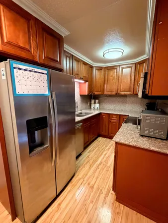 a kitchen with stainless steel appliances granite countertop a refrigerator a sink and a stove