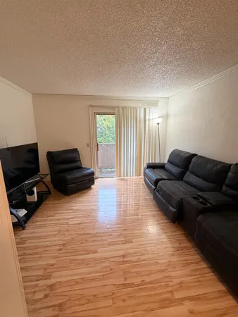 a living room with furniture a flat screen tv and a window
