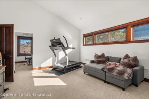 a living room with furniture gym equipment and a flat screen tv