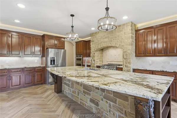 a kitchen with kitchen island granite countertop a stove and a center island
