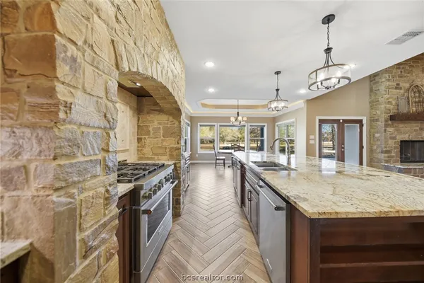a kitchen with granite countertop a stove and a sink