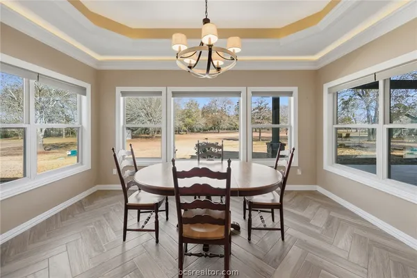 a dining room with furniture a chandelier and wooden floor