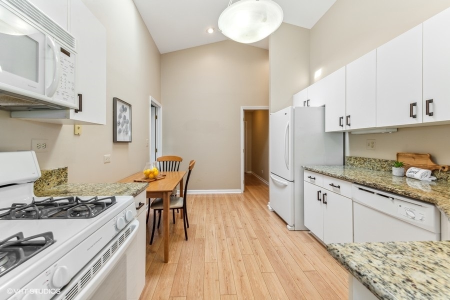 393 Bentley Place Buffalo Grove, IL 60089 - Photo 7 of 16 a kitchen with stainless steel appliances granite countertop a stove a refrigerator a sink dishwasher and white cabinets with wooden floor