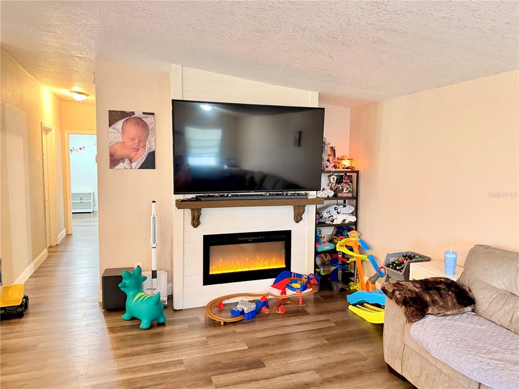 685 Eagle Watch Road Oak Hill, FL 32759 - Photo 2 of 21 a living room with furniture and a flat screen tv
