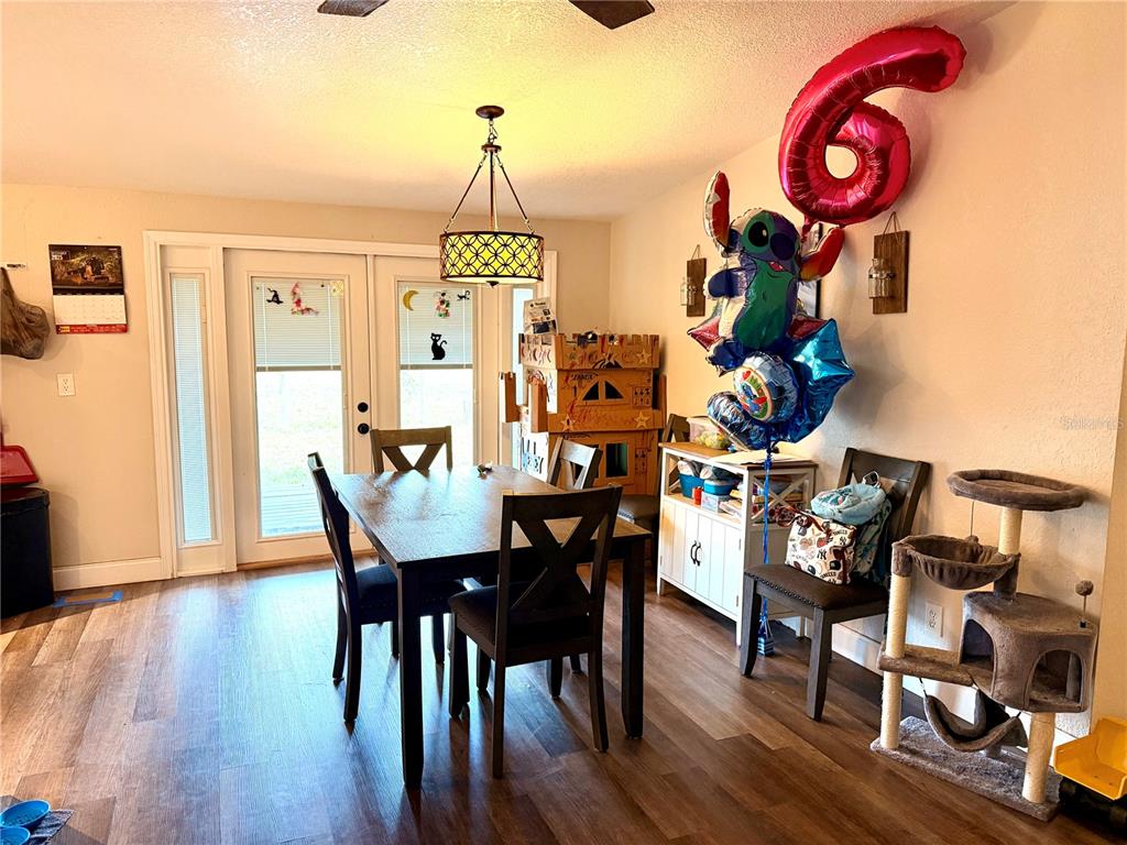 685 Eagle Watch Road Oak Hill, FL 32759 - Photo 4 of 21 a view of a dining room with furniture and wooden floor