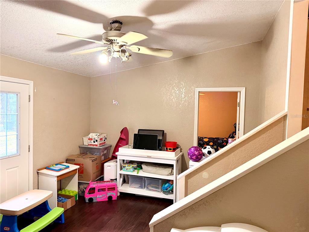 685 Eagle Watch Road Oak Hill, FL 32759 - Photo 6 of 21 a bedroom with furniture and a chandelier fan