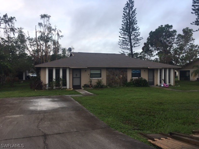 7460 Garry Road Fort Myers, FL 33967 - Photo 1 of 21 a front view of a house with a yard and trees