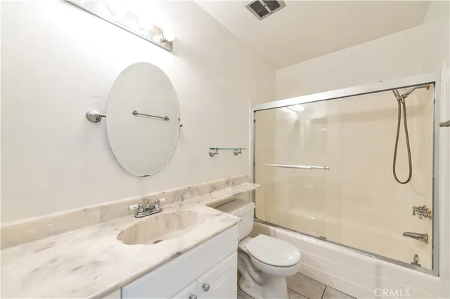 a bathroom with a granite countertop sink a toilet and a mirror