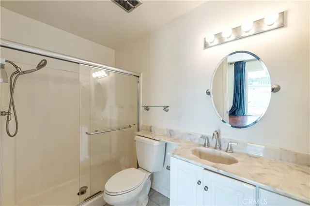 a bathroom with a granite countertop sink mirror vanity and toilet