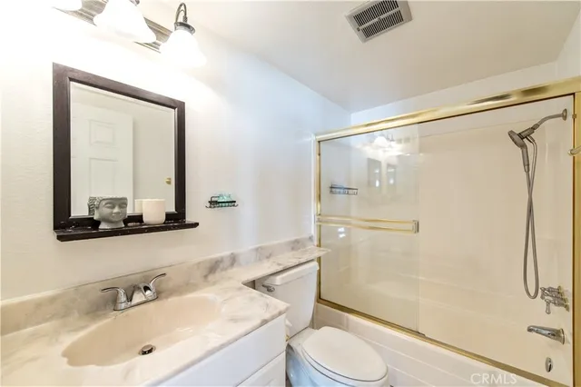 a bathroom with a sink mirror toilet and shower
