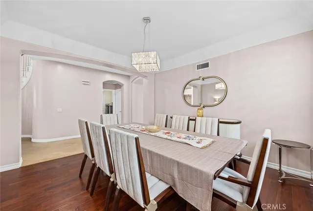 a view of a dining room with furniture a chandelier and wooden floor
