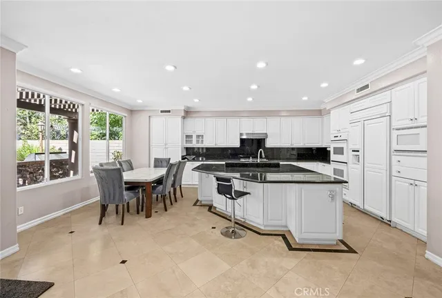 a kitchen with stainless steel appliances kitchen island granite countertop a sink and cabinets