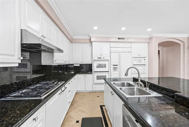 a kitchen with granite countertop a sink stainless steel appliances and cabinets