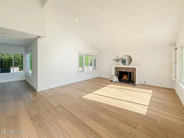 a view of empty room with fireplace and wooden floor