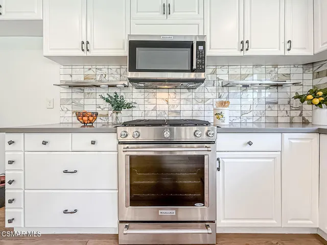 a stove top oven sitting inside of a kitchen