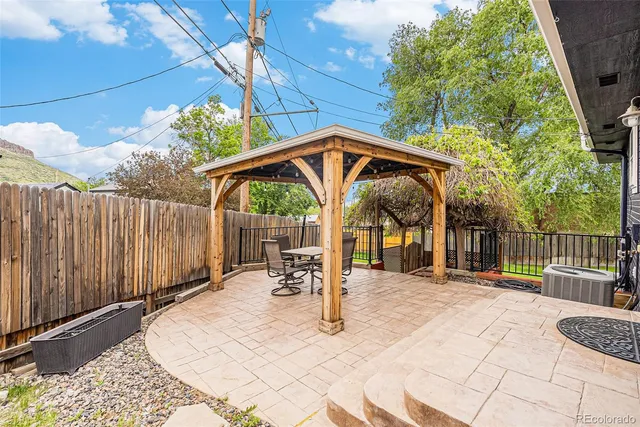 a view of a patio with table and chairs with wooden fence and plants