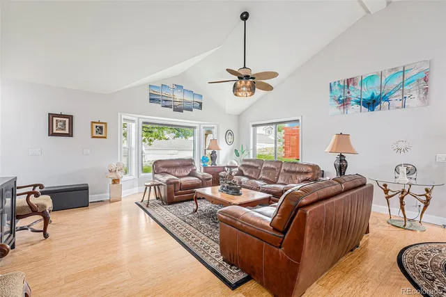 a living room with furniture kitchen view and a window