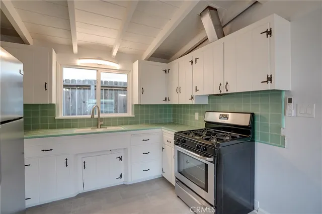 a kitchen with granite countertop white cabinets and white appliances