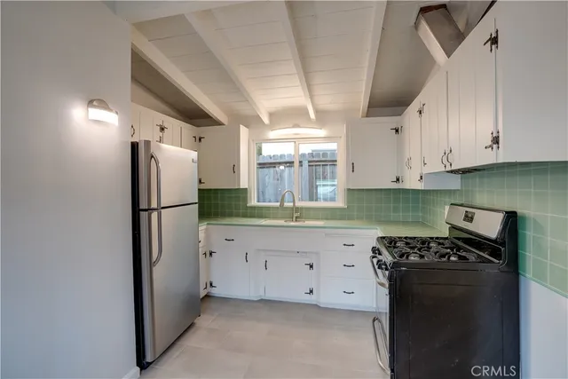 a kitchen with granite countertop a refrigerator and a stove top oven