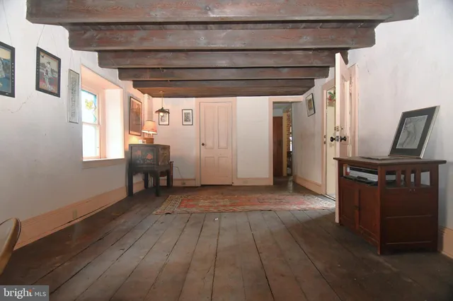 a view of a livingroom with wooden floor and furniture