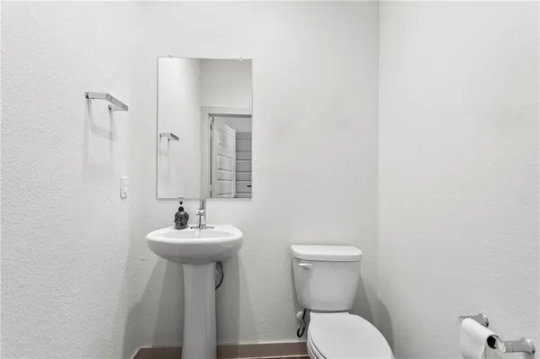 a bathroom with a sink mirror and toilet
