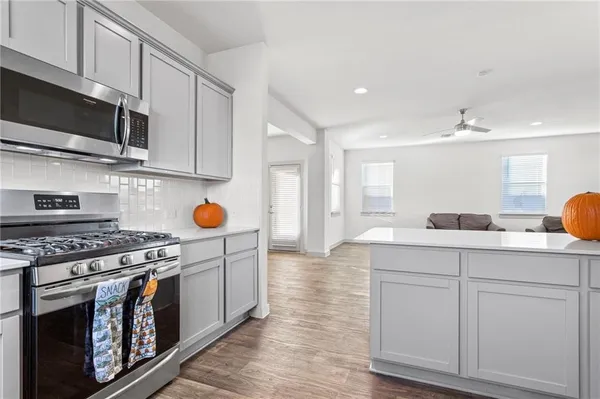 a kitchen with stainless steel appliances granite countertop a stove a sink and a microwave