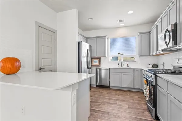 a kitchen with a sink a stove a refrigerator and cabinets