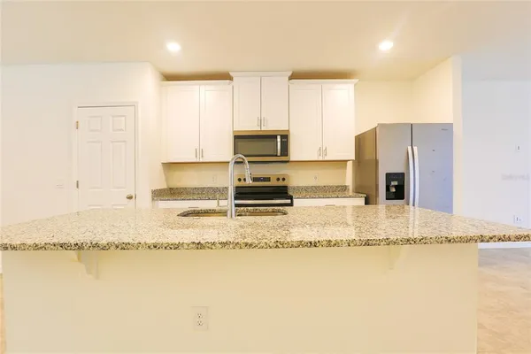 a large kitchen with sink and a refrigerator