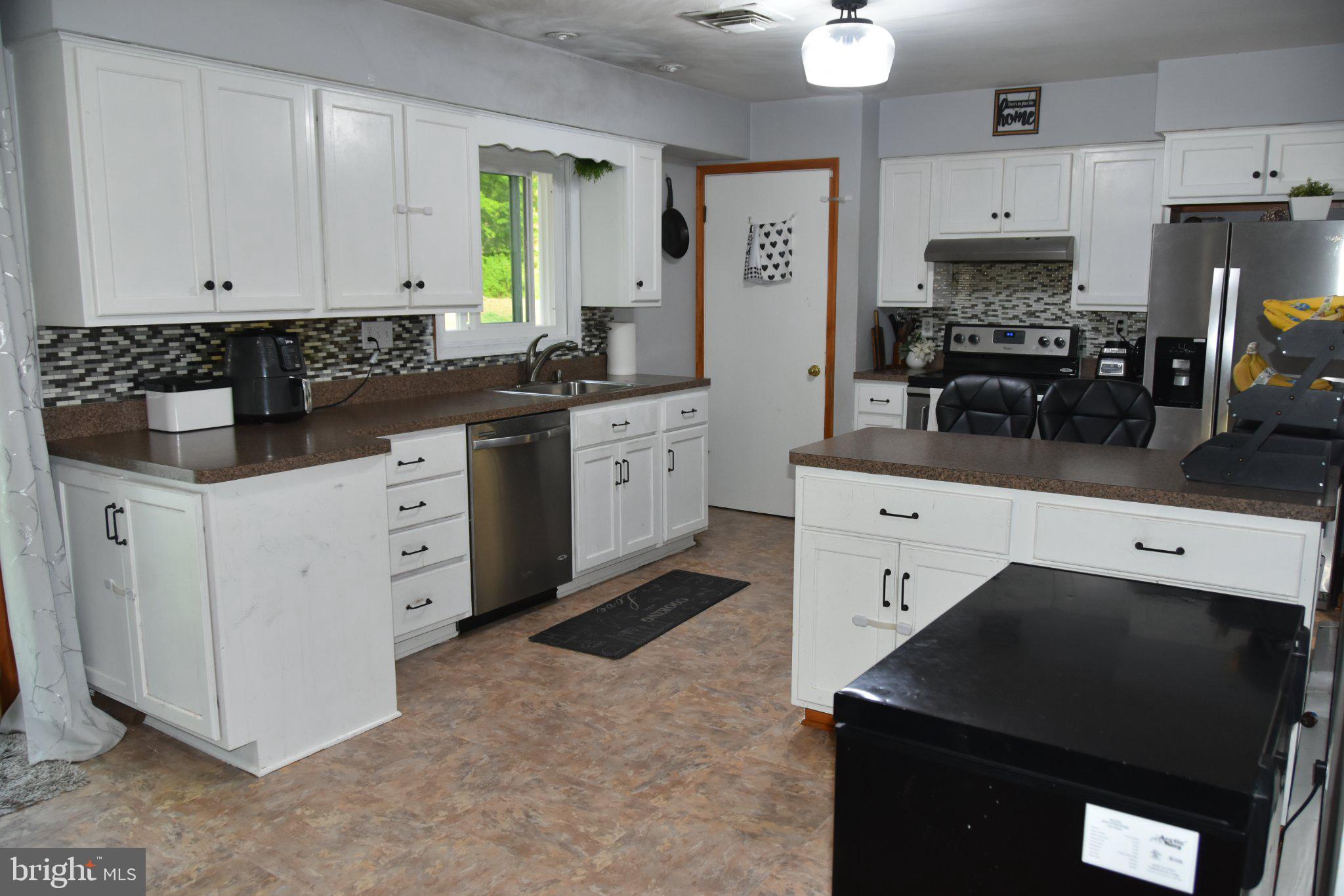 8610 Croom Road Upper Marlboro, MD 20772 - Photo 10 of 14 a kitchen with stainless steel appliances a stove a sink a refrigerator a counter top space and cabinets