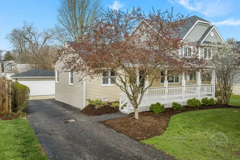 a view of a house next to a yard with big trees