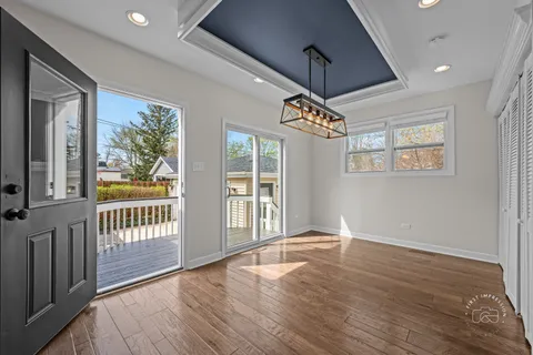 a view of a kitchen with a fridge and wooden floor