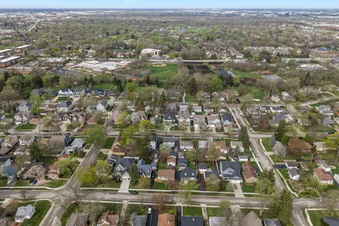an aerial view of residential houses with outdoor space and trees