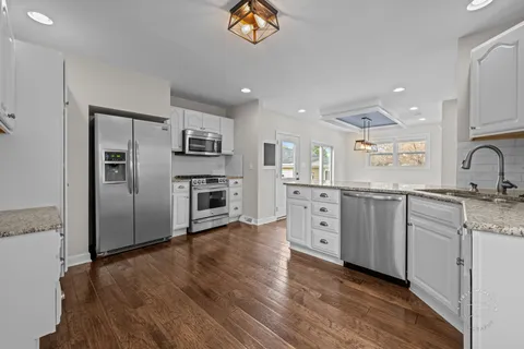 a kitchen with granite countertop a refrigerator and a sink