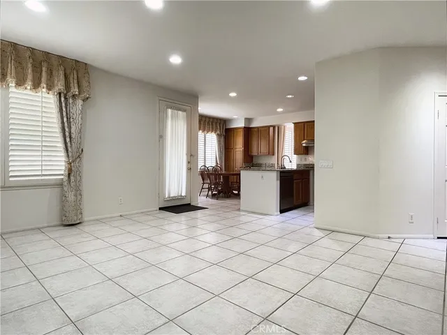 a kitchen with stainless steel appliances granite countertop a sink a stove a dining table and chairs