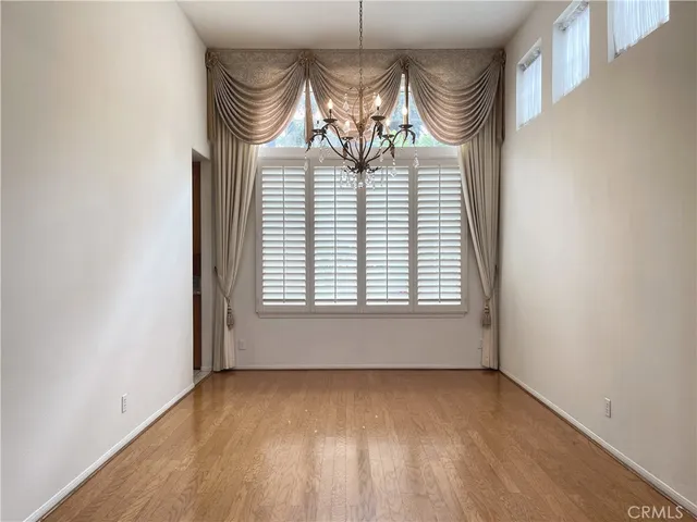 an empty room with wooden floor and hallway