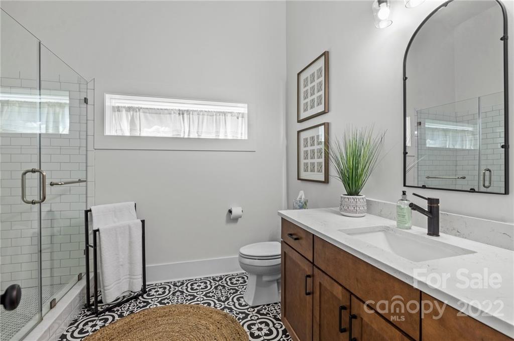 11099 Pheasant Run Tega Cay, SC 29708 - Photo 40 of 47 a bathroom with a granite countertop sink mirror vanity and toilet